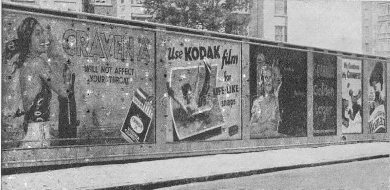 A row of vintage street hoardings advertising Craven A cigarettes, Kodak film, Guinness and other brands.